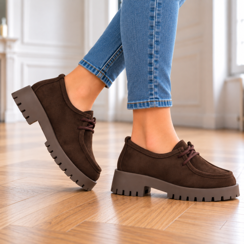 Brązowe zamszowe buty na drewnianej podłodze (1).png