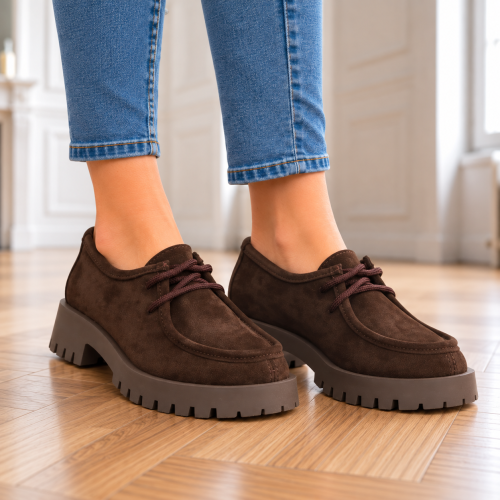 Brązowe zamszowe buty na drewnianej podłodze.png