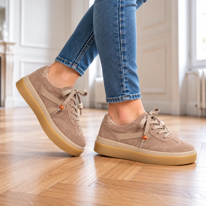 Beżowe sneakersy na drewnianej podłodze (3).png
