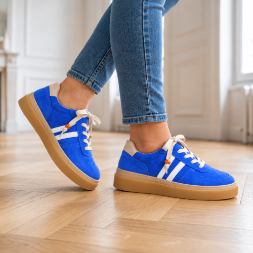 Niebieskie sneakersy na drewnianej podłodze.png