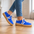 Niebieskie sneakersy na drewnianej podłodze.png