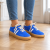 Kobaltowe sneakersy na drewnianej podłodze.png