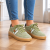 Zielone zamszowe sneakersy na parkiecie.png
