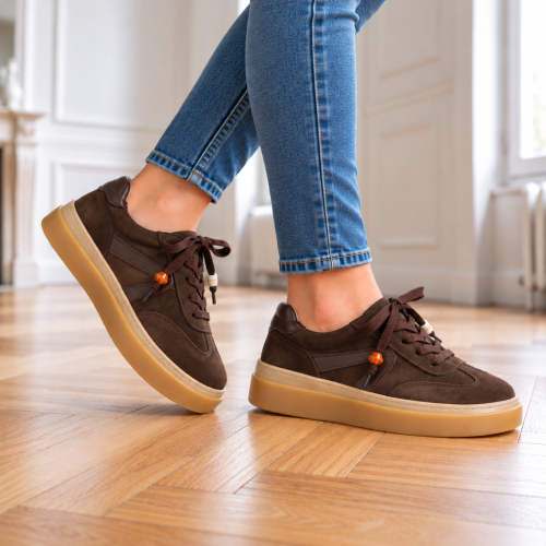 Brązowe sneakersy na drewnianej podłodze (3).png