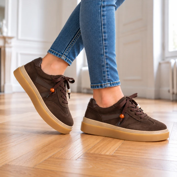 Brązowe sneakersy na drewnianej podłodze (3).png