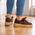 Brązowe sneakersy na drewnianej podłodze (2).png