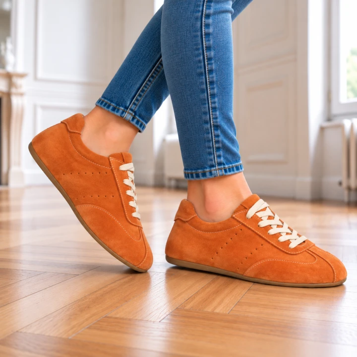 Rdzawobrązowe sneakersy w jasnym wnętrzu.png