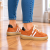 Pomarańczowe sneakersy na drewnianej podłodze (2).png