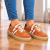 Rdzawo-pomarańczowe sneakersy na drewnianej podłodze.png